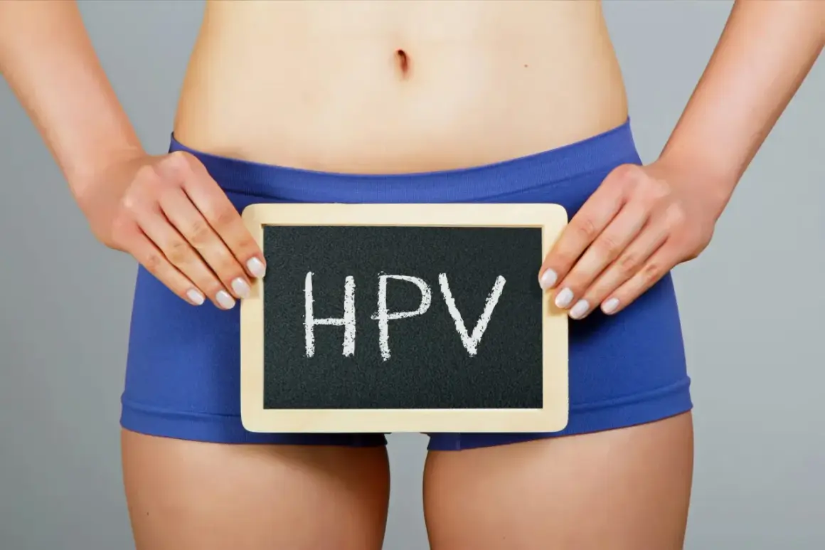 Kobieta trzyma tabliczkę z napisem HPV. Wirus ten może powodować kłykciny kończyste.